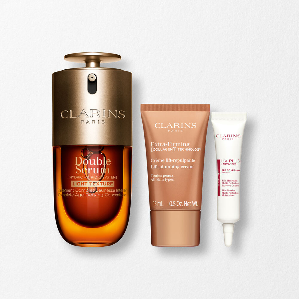 A 50ml bottle of Clarins Double Serum Light Texture among turmeric and proven&ccedil;al reed leaves against an orange background.