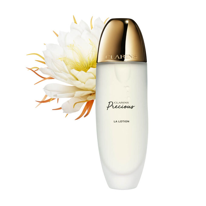 Packshot of Clarins Precious Treatment Essence close to a Moonlight flower on a dark background.