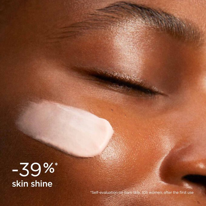 Woman wearing SOS Primer Mattifying by Clarins to illustrate that it reduces skin shine by 39%.