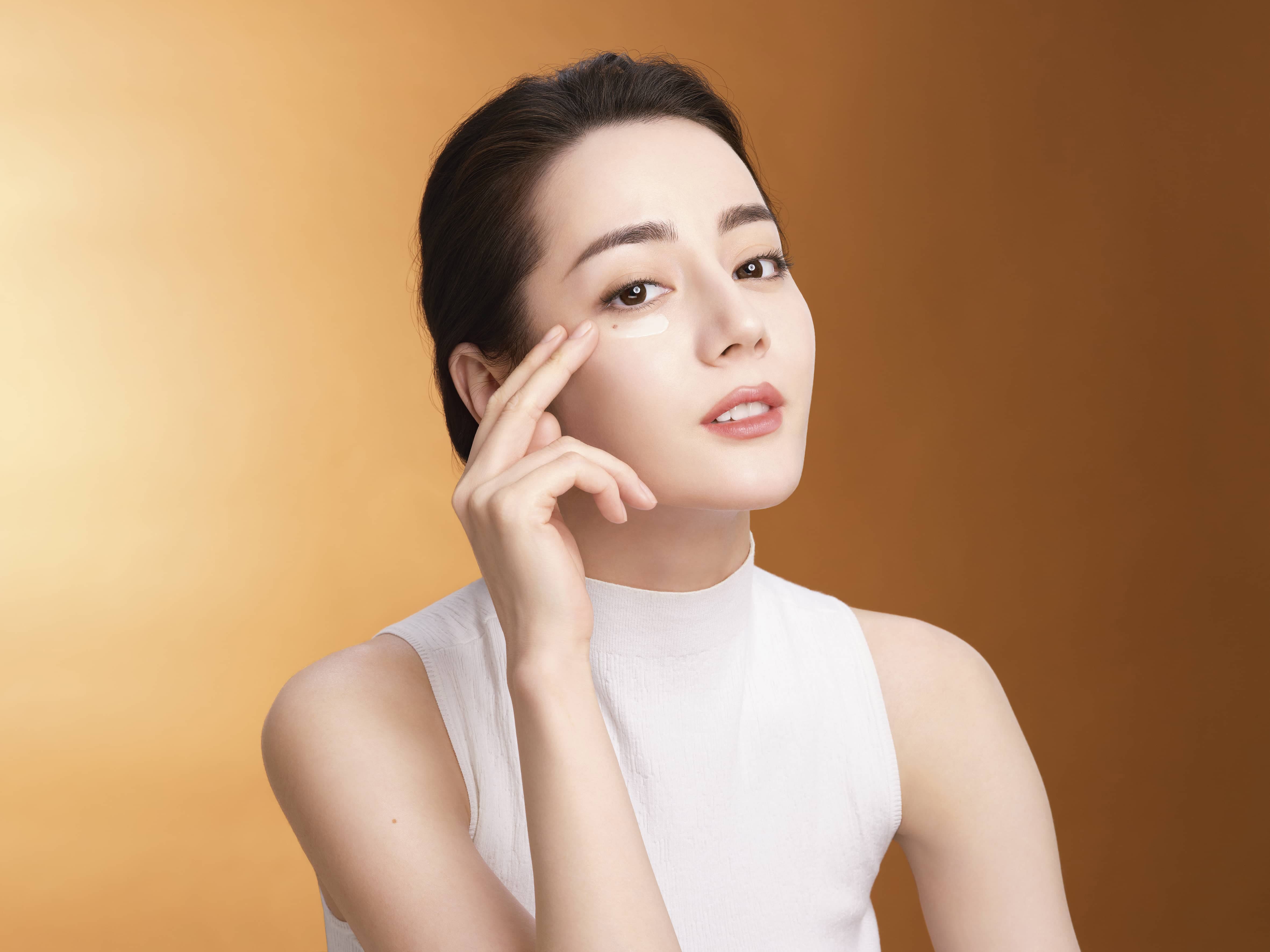 Model apply serum on eyes area